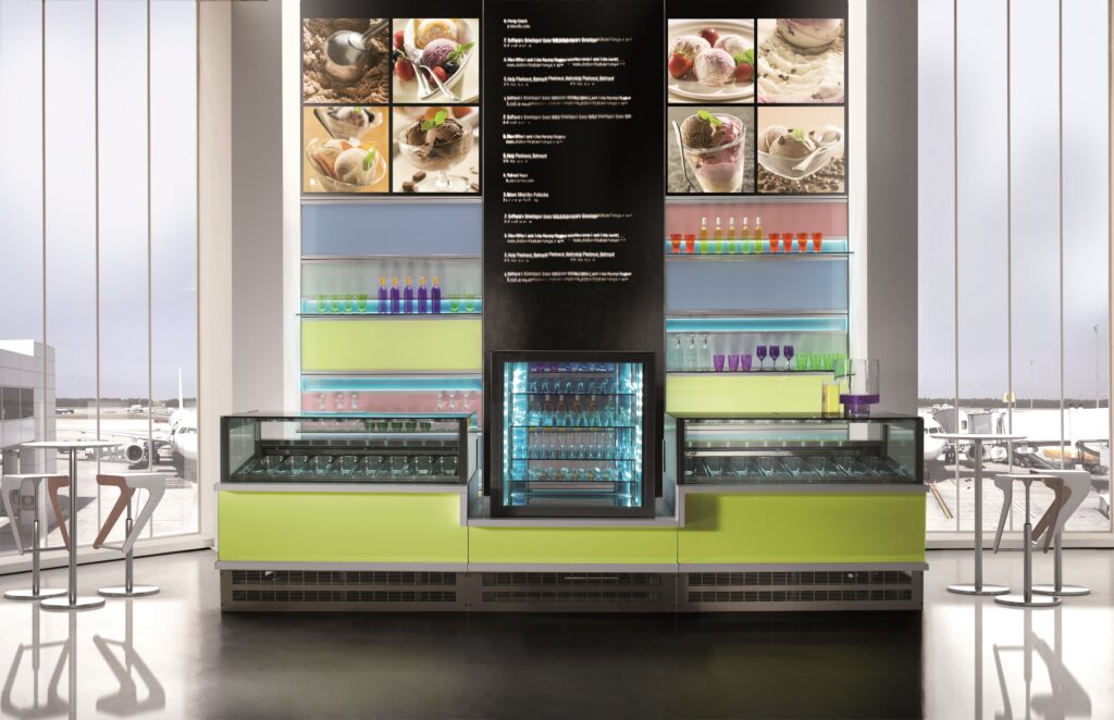 Vert in the center of gelato case with green laminate.  Large menu board in background